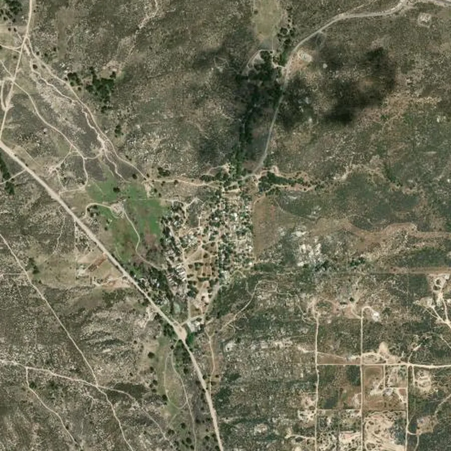 Satellite view around Live Oak Springs, California, showing a compact cluster of homes surrounded by chaparral and scrub, with a 2 km box outlined in orange